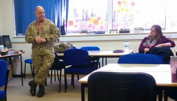 Serving Army Officer Works With Students Studying Impact Of War